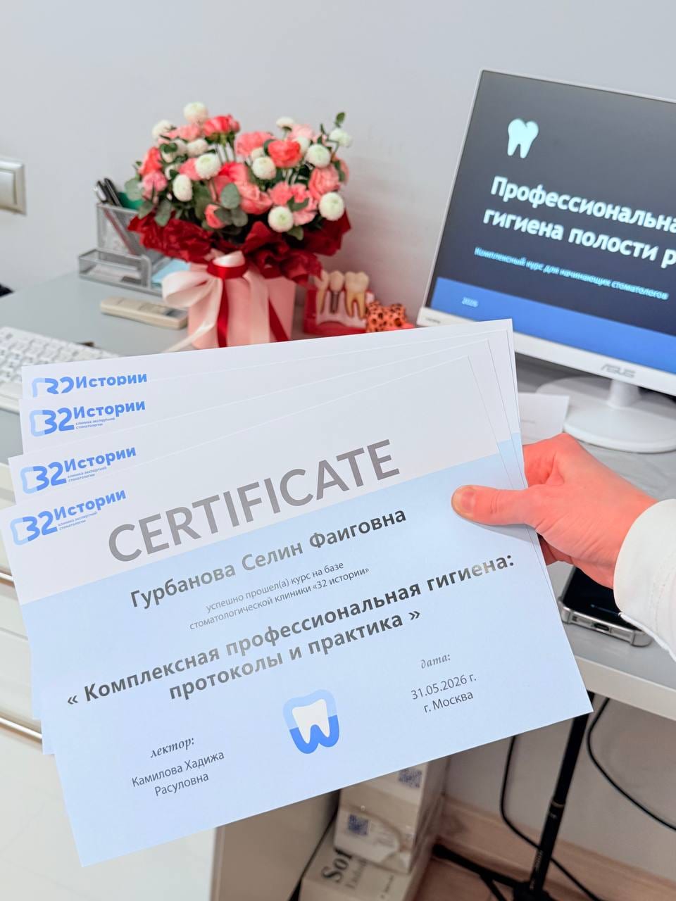 Именные сертификаты курса и слайд программы на экране в клинике
